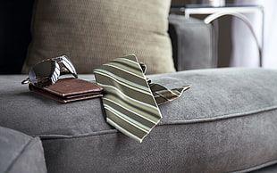 white and black stripe necktie on sofa